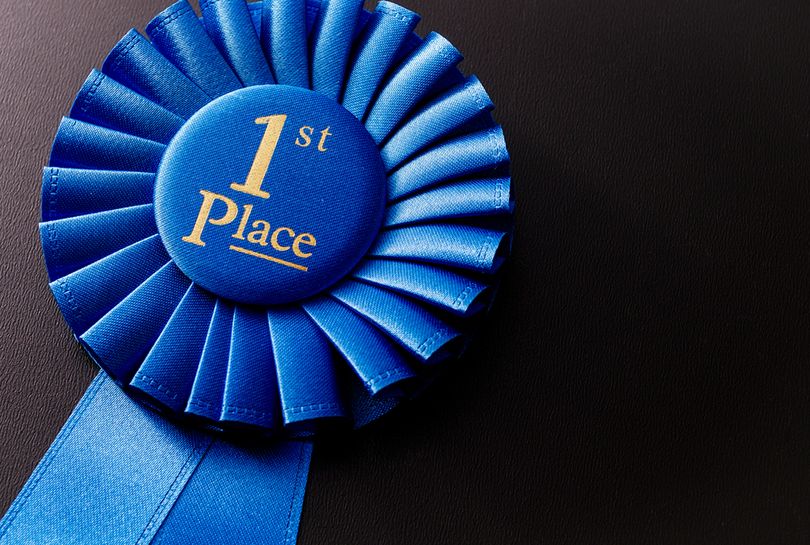 1st Place Blue Rosette Against Black Background